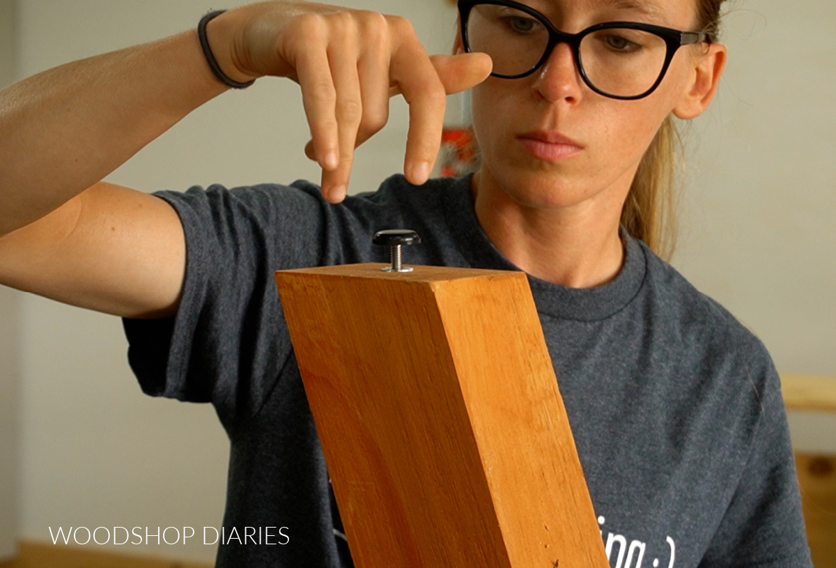 Threading foot levelers into inserts on bottom of loveseat legs