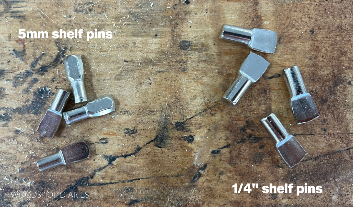 5mm shelf pins on workbench next to ¼" shelf pins to show size difference