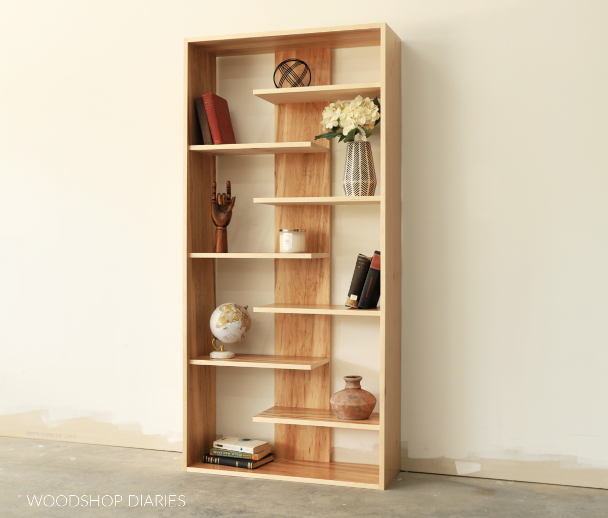 Finished DIY modern maple plywood bookshelf with books and décor against white wall