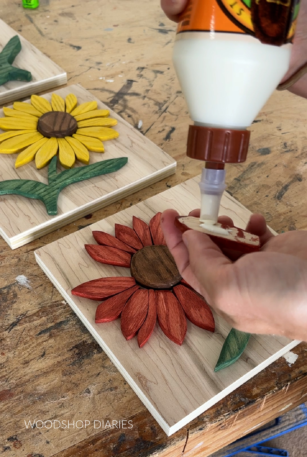 Applying wood glue to back side of wood sunflower petal