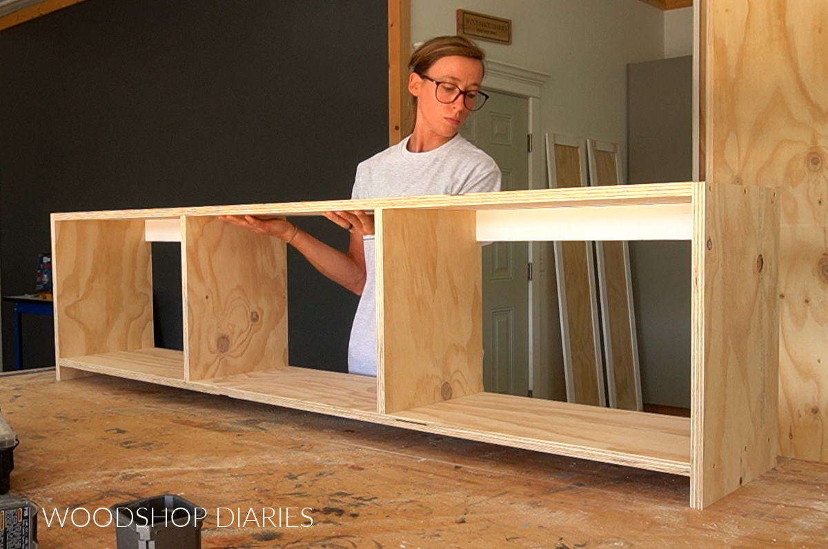 Shara Woodshop Diaries placing mudroom cubby cabinet on workbench