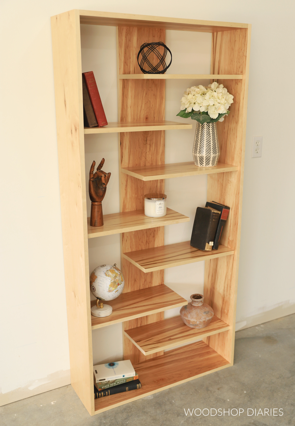 Close up of plywood bookshelf with alternating left and right shelves on each side