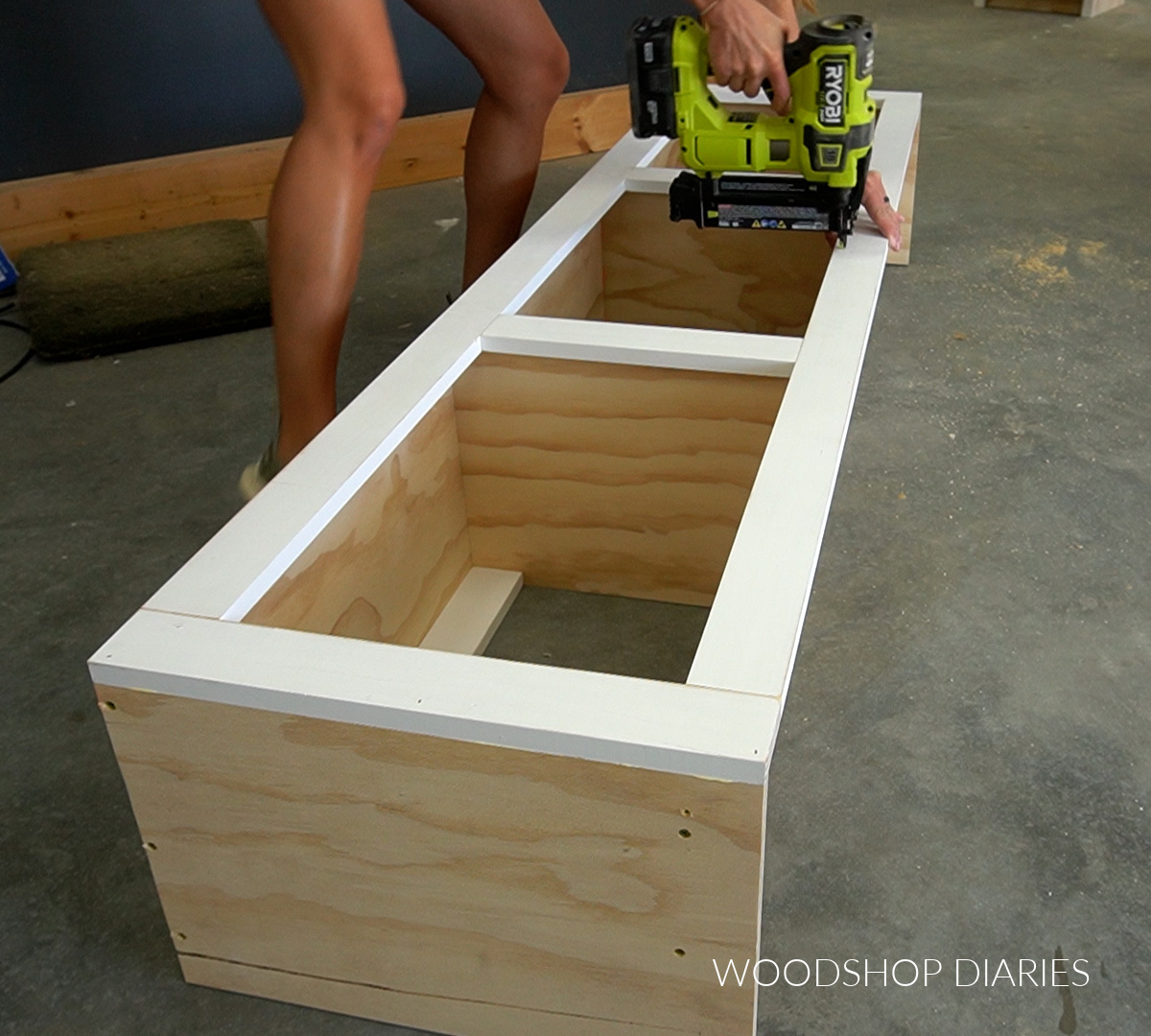 Shara Woodshop Diaries nailing face frame on front of cabinet on workshop floor