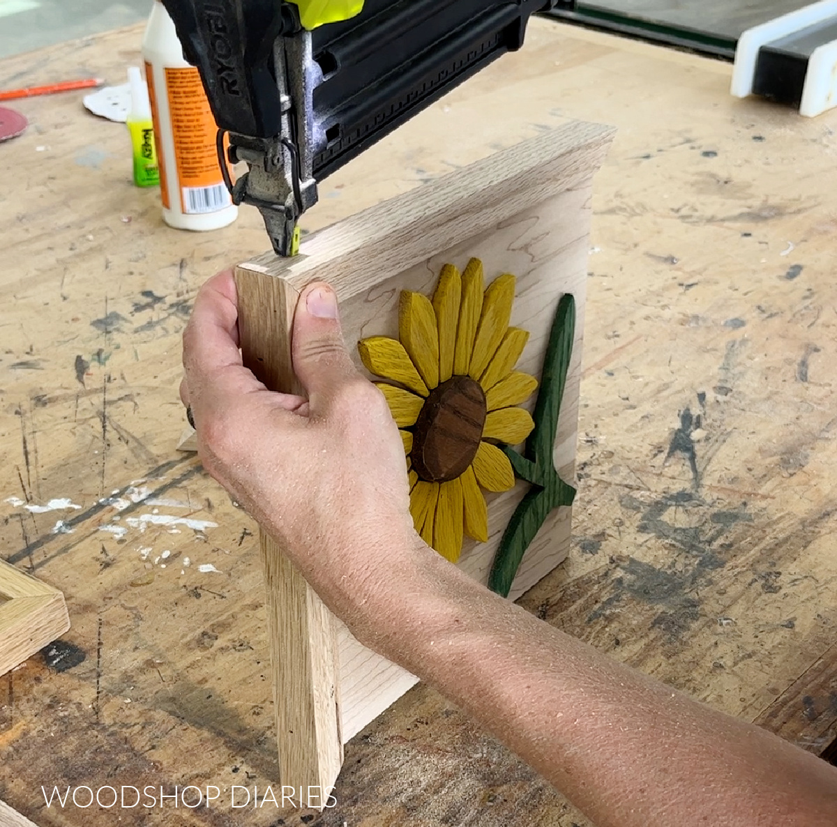 Using a brad nailer to attach 1x2 frame around plywood backer