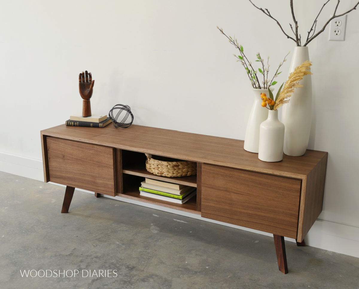 Finished walnut plywood mid century modern console cabinet with two doors and a middle shelf