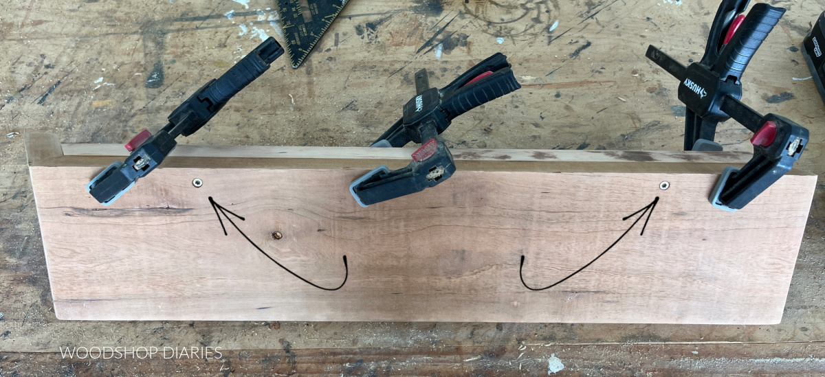 Image of underside of wooden DIY floating shelf showing locations of screws