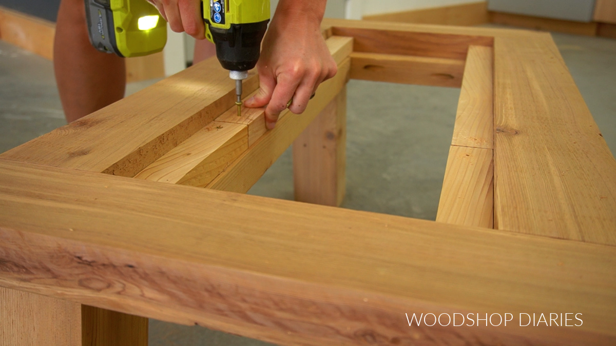 Installing spacer blocks underneath coffee table slats in top frame with screws