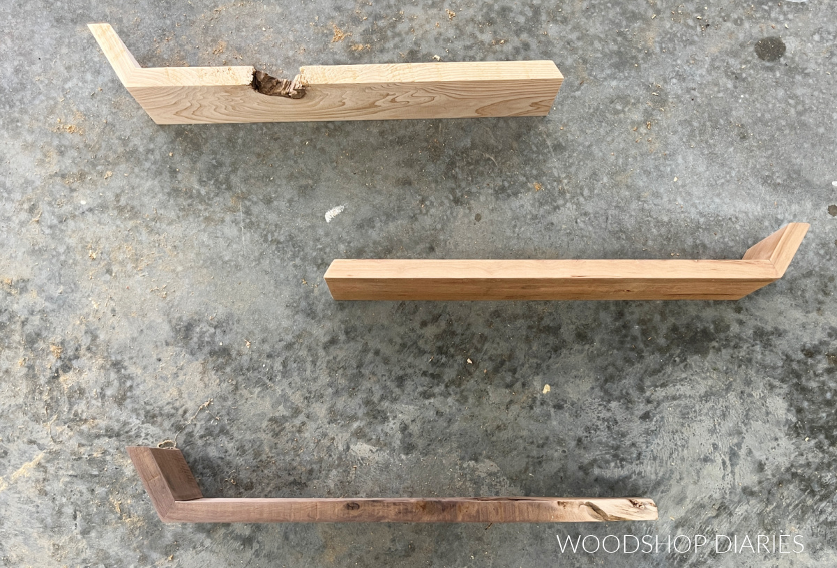 Three unfinished floating shelves made from different woods laying on concrete floor