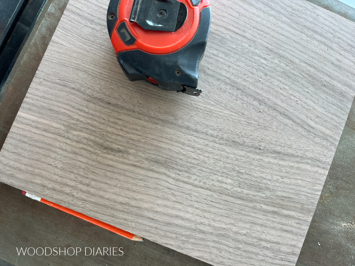 Close up of unfinished walnut plywood with tape measure on table saw