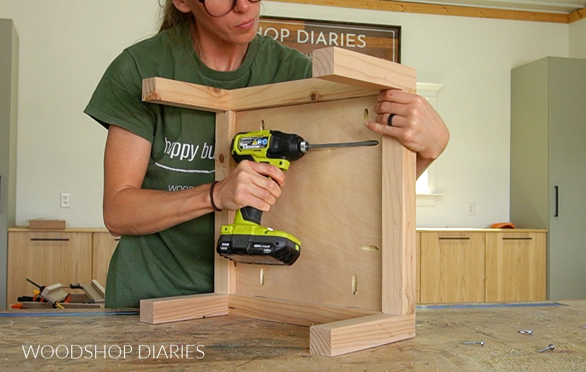 Shara Woodshop Diaries installing center plywood panel into 2x2 bookshelf base frame