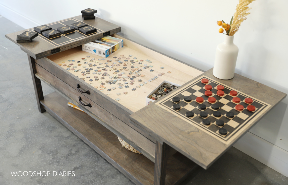 DIY board game table with tops flipped open showing checkers on one side and tic tac toe on the other side with a puzzle underneath