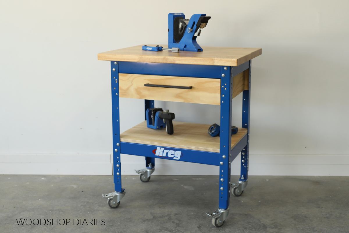 Kreg Universal Workbench with hardwood top and caster wheels built out with large drawer at top and a wooden shelf along bottom