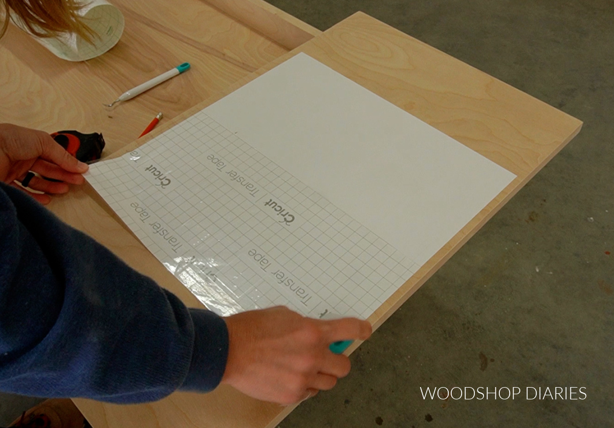 applying checker board stencil to wooden table top