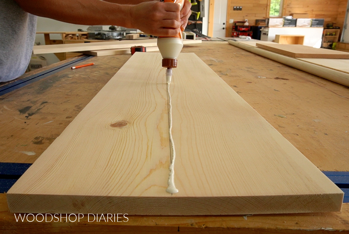 applying wood glue along centerline of board