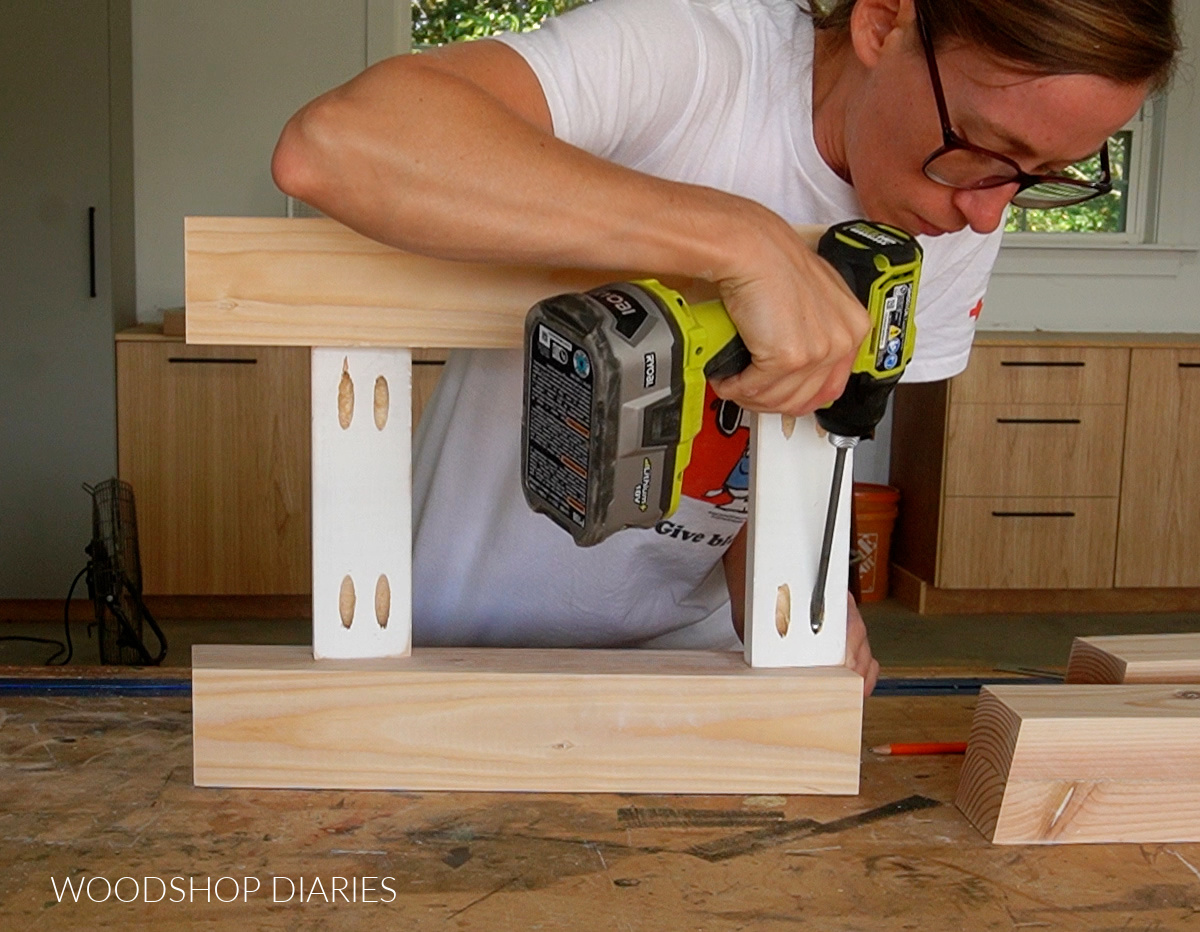 Shara Woodshop Diaries installing short side supports between bench legs with pocket holes and screws