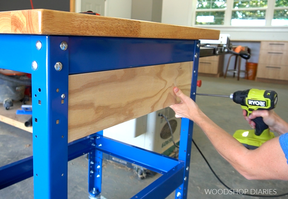 Shara Woodshop Diaries installing back plywood panel to workbench frame through predrilled holes