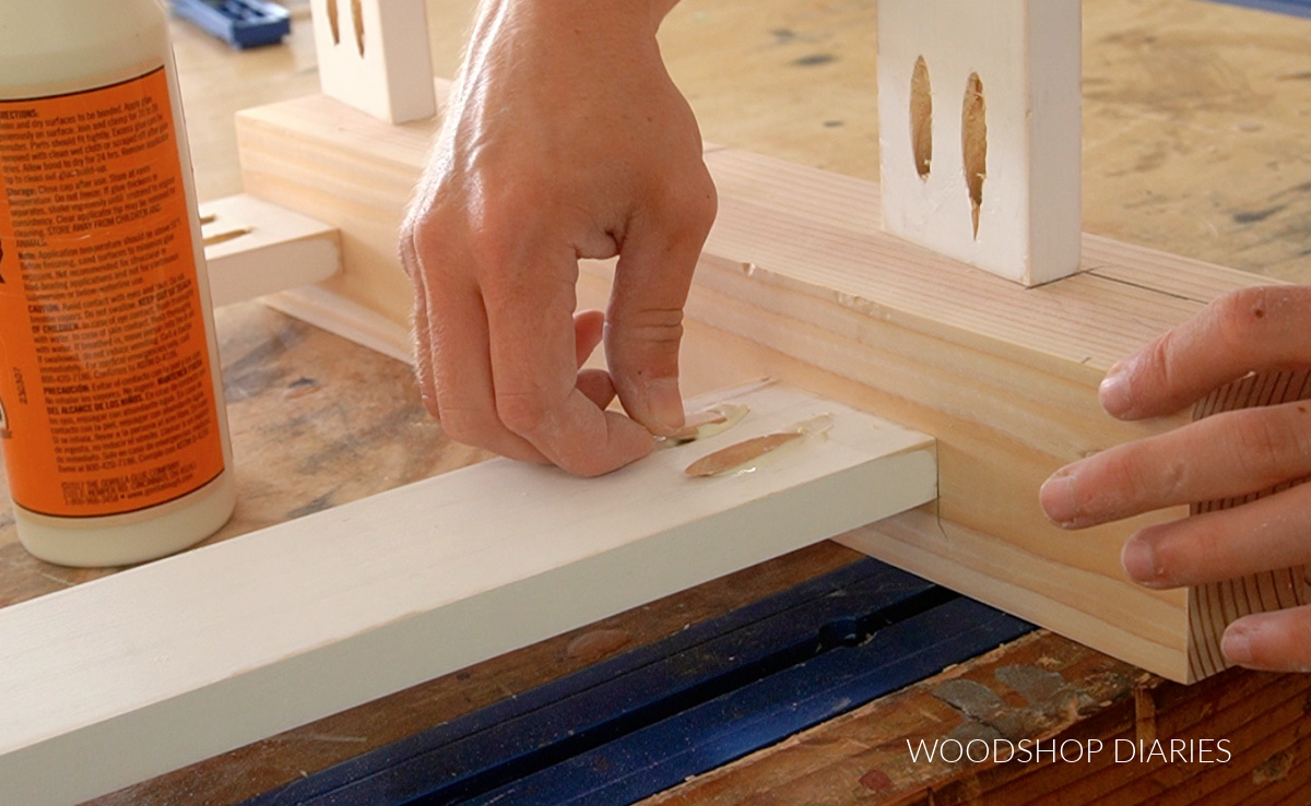 Close up of installing pocket hole plugs into pocket holes on bench frame