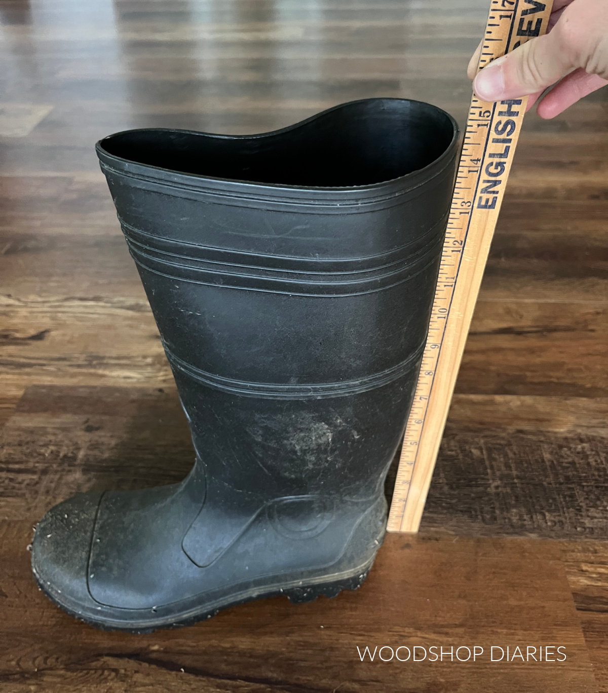 Yard stick next to rain boot showing 15" height