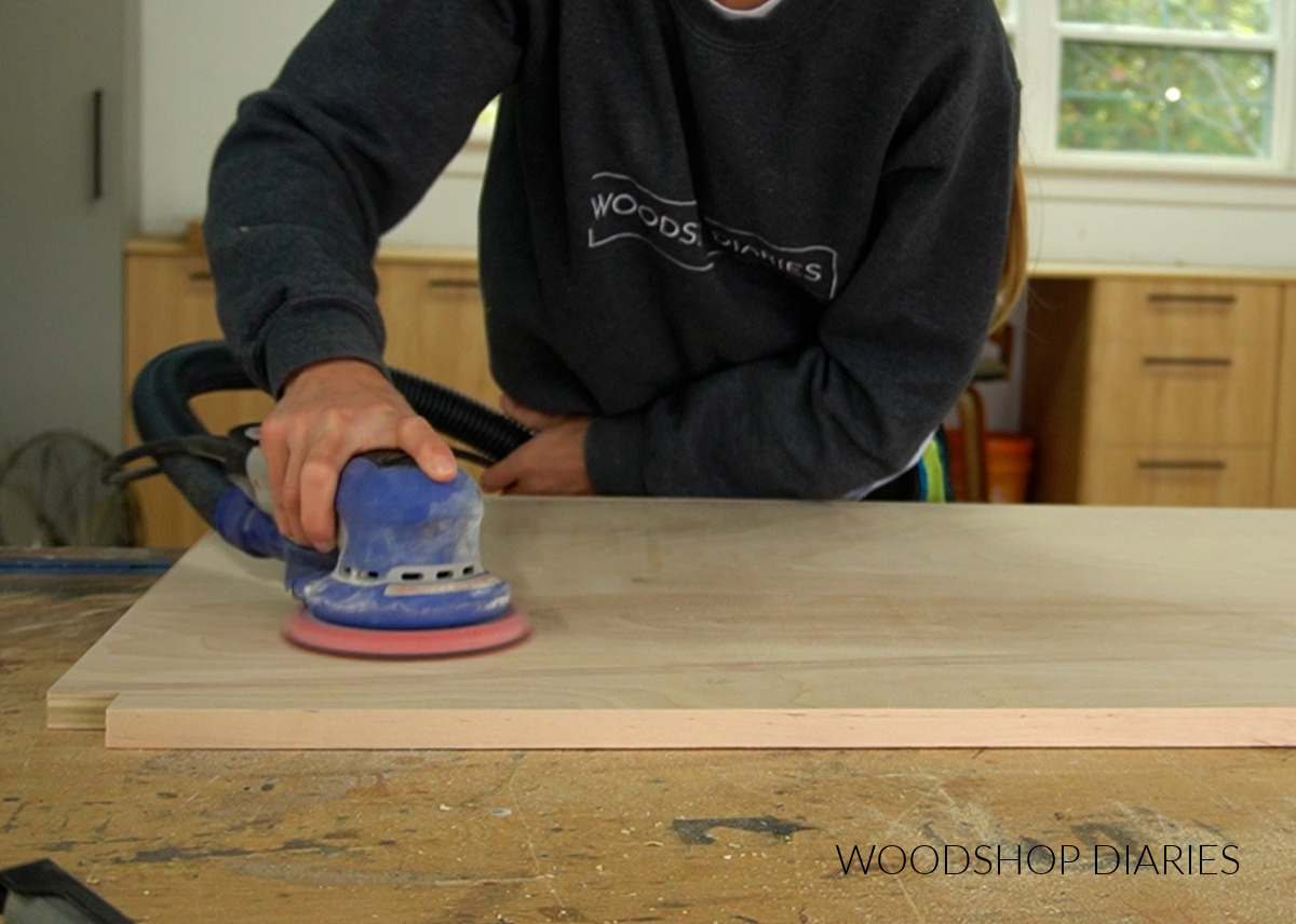 Shara Woodshop Diaries sanding plywood on workbench