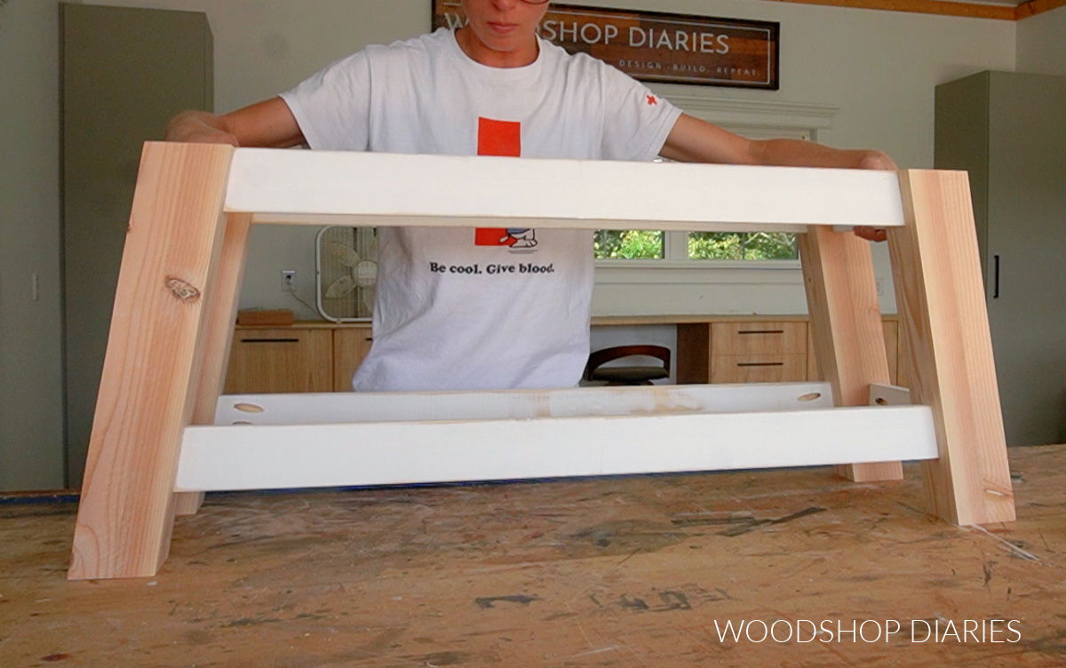 Shara Woodshop Diaries placing assembled shoe bench frame on workbench