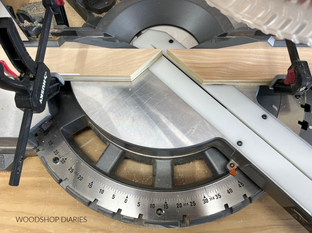 scrap blocks on miter saw base cut at 45 degree angles