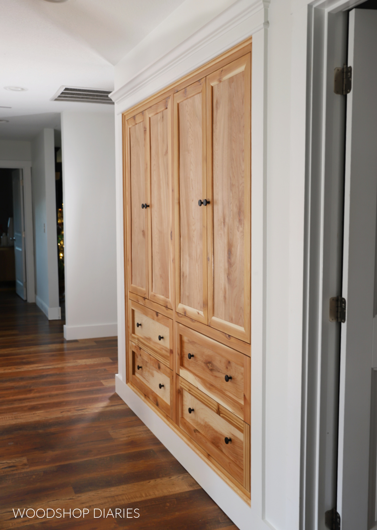 Warm wood custom built in cabinets in hallway with white walls