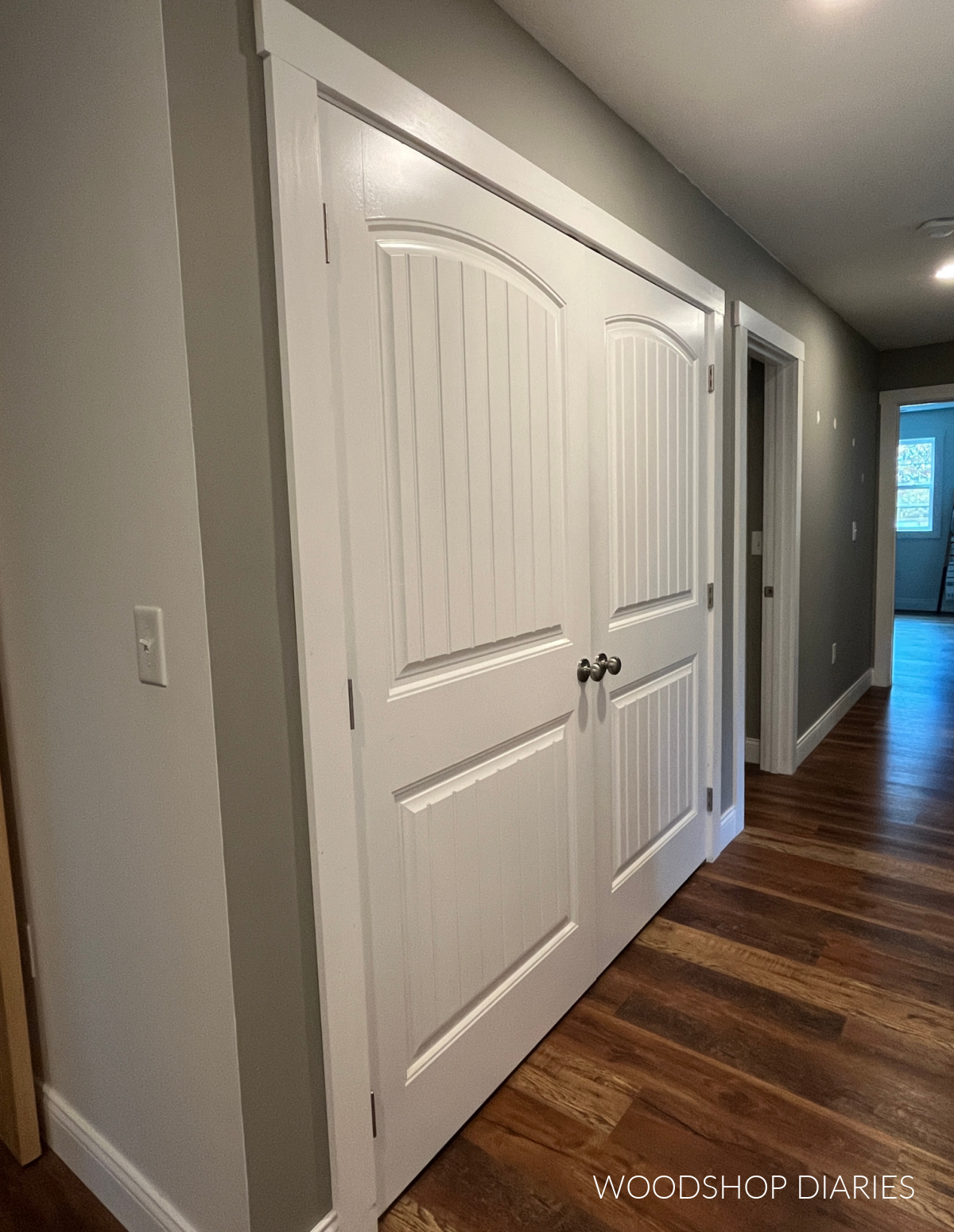 Hallway closet before image showing plain white double doors in hallway