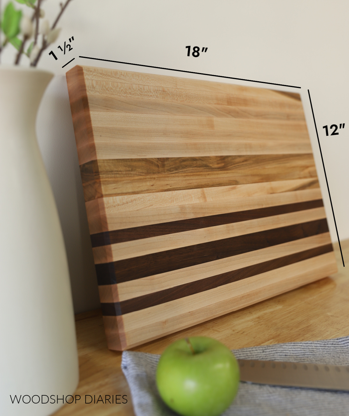 cutting board propped against the wall with dimensions showing 1 ½" thick, 18" long and 12" wide