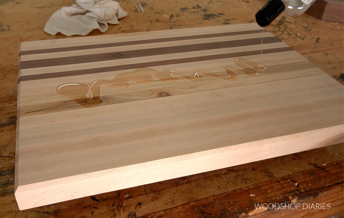 Applying cutting board oil to cutting board on workbench