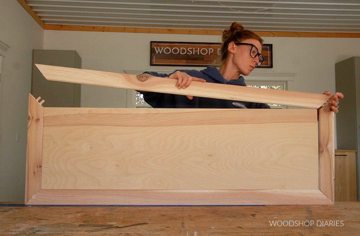 Shara Woodshop Diaries assembling cabinet door with cedar tongue and groove with ¼" plywood panel with dowels and wood glue on workbench