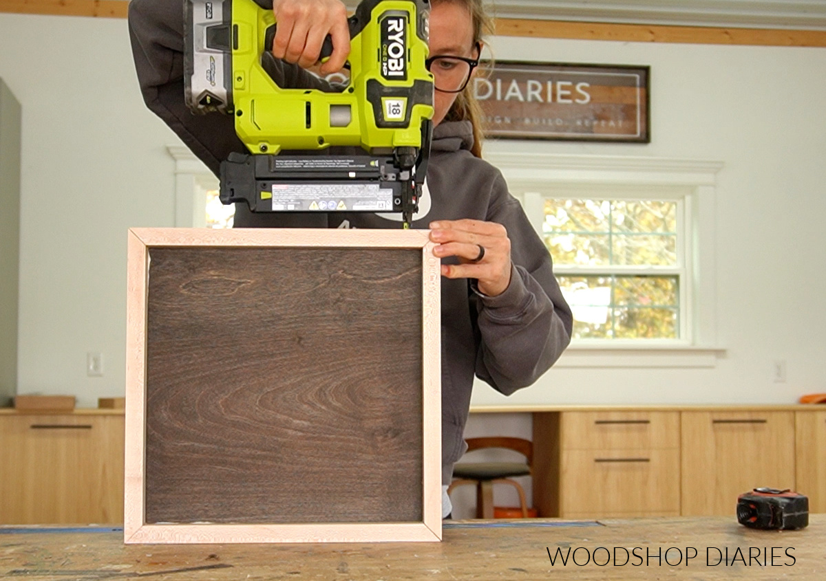 Shara Woodshop Diaries brad nailing trim boards around edges of wooden tic tac toe board tray
