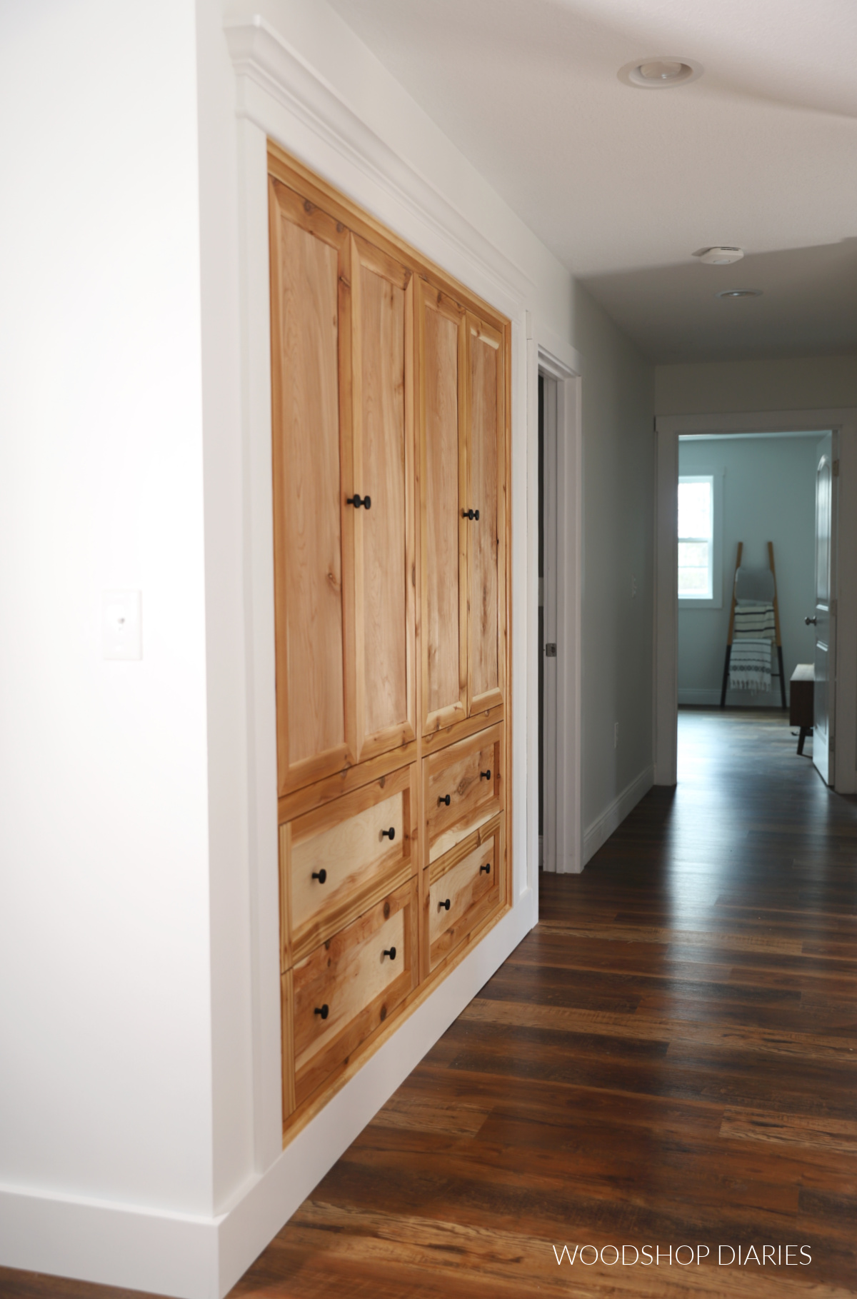 Angled view down hallway focusing on wood built ins in closet