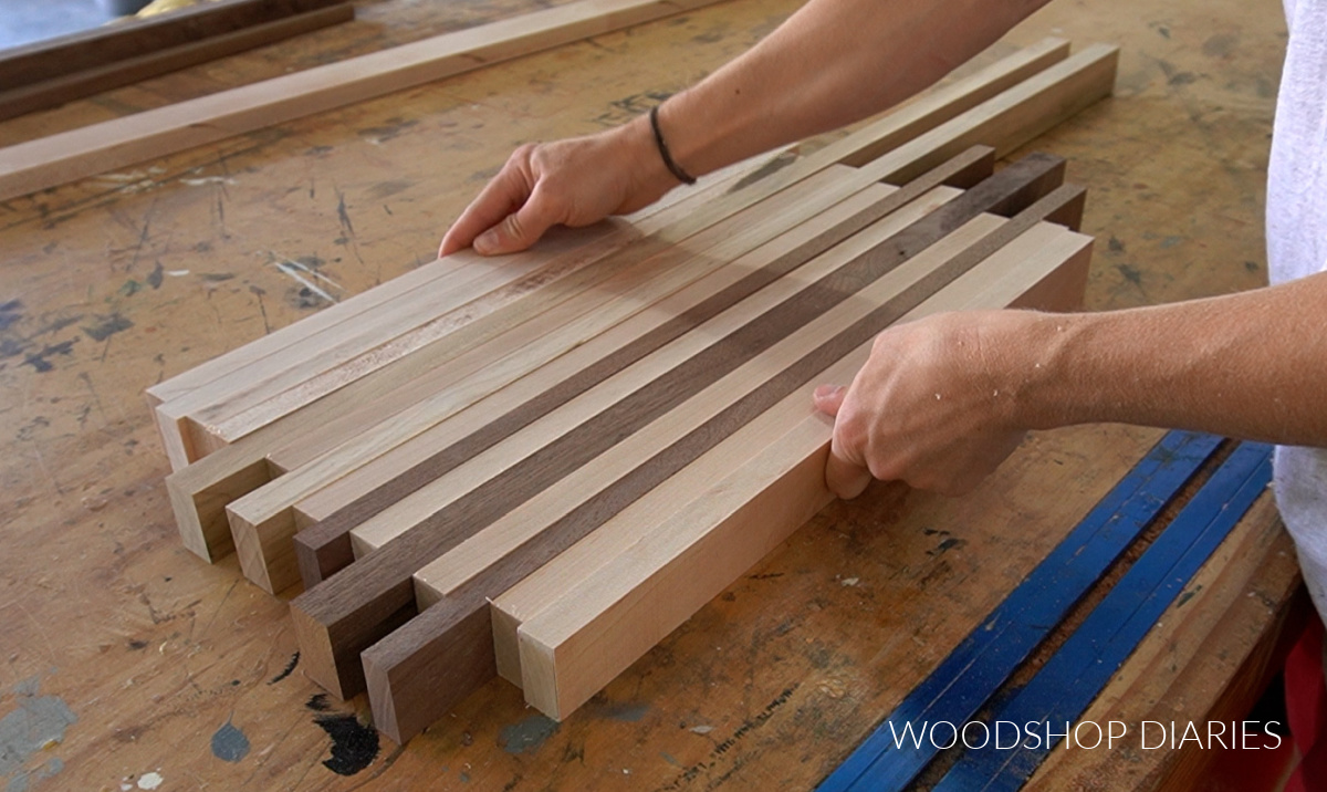 laying maple and walnut boards out together on workbench to make cutting board design