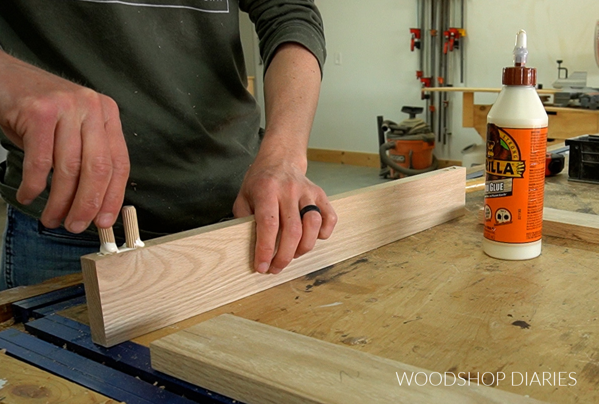 Gluing dowel pins into dowel holes on edge of door frame