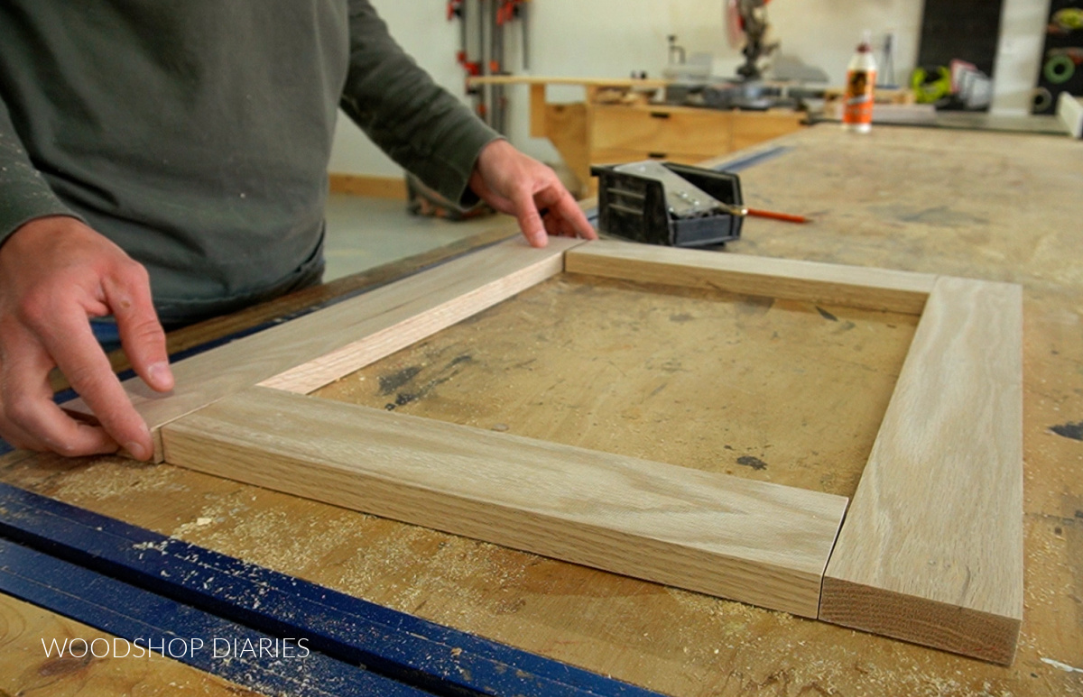 Shara Woodshop Diaries laying out door frame pieces on workbench to assemble with dowel pins