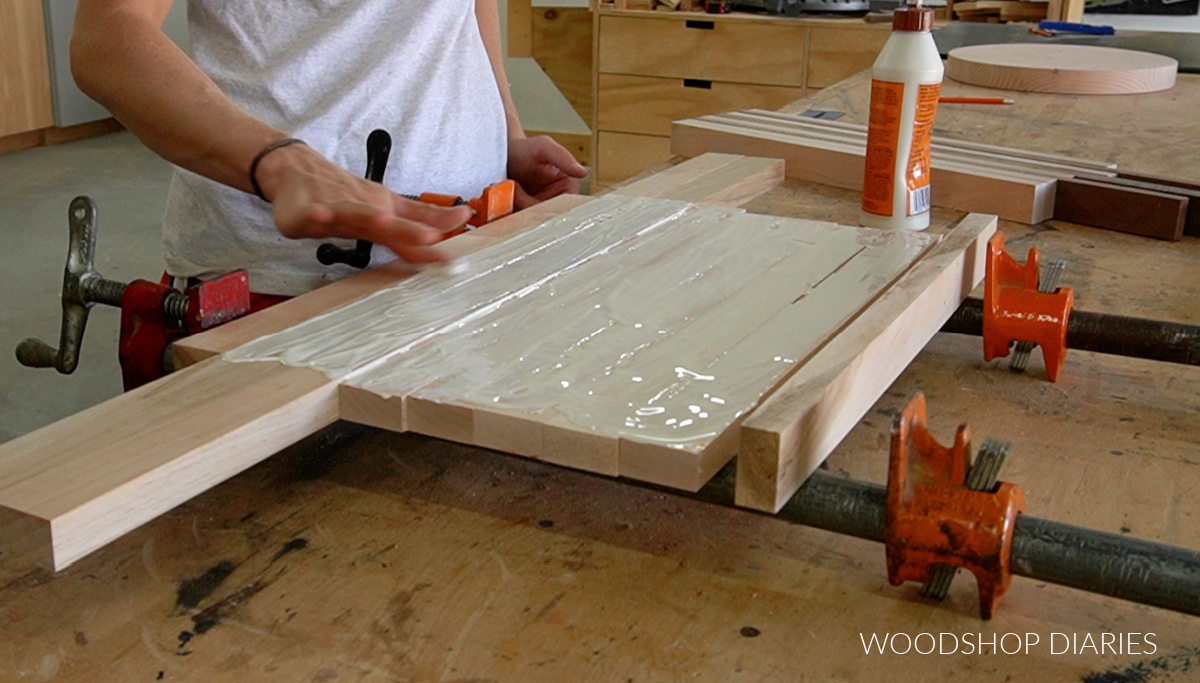 applying glue to cutting board pieces on clamps