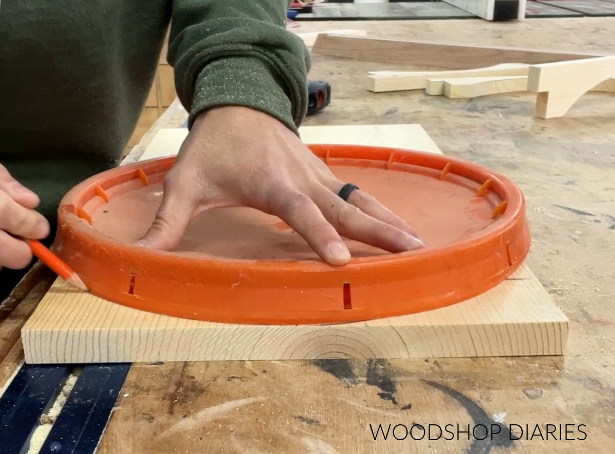 Shara Woodshop Diaries tracing around lid of 5 gallon bucket onto 1x12 board