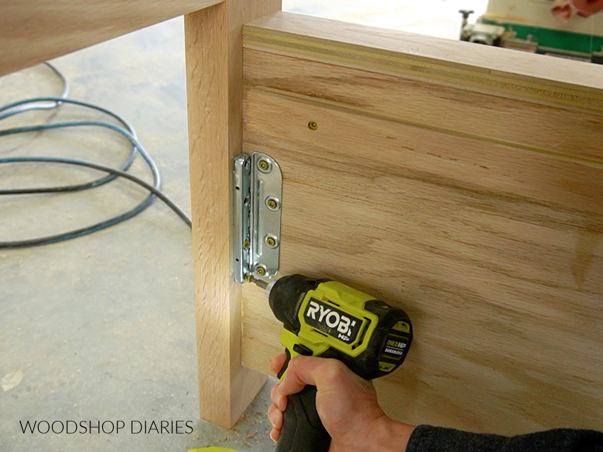 Screwing bed rail brackets into the headboard leg to assemble