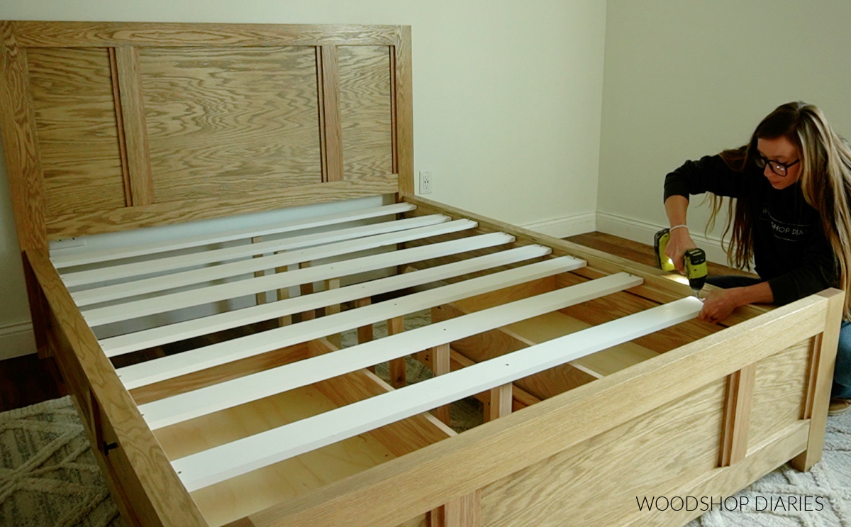 Shara Woodshop Diaries installing bed slats onto bed frame using screws