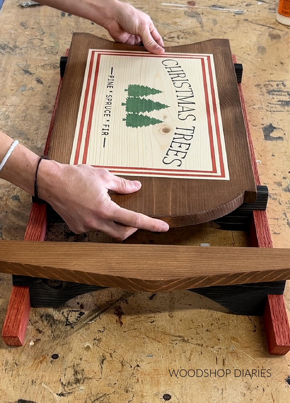 Placing finished Wooden Sled seat onto sled frame to glue in place