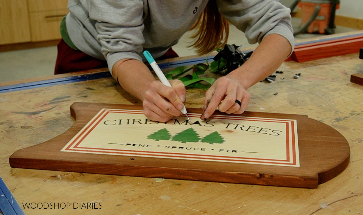 Removing stencil from board after staining Christmas Tree design onto sled seat