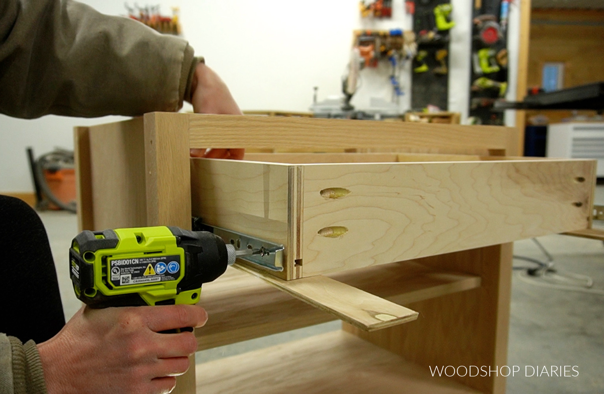 Close up of driver driving screws to attach drawer box to drawer slides