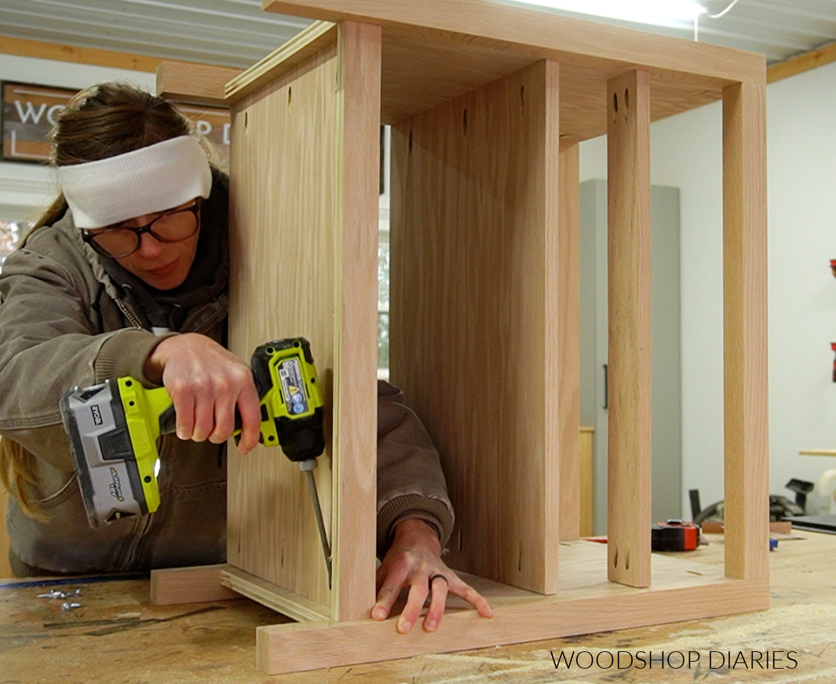 Shara Woodshop Diaries building modern nightstand on workbench top--attaching bottom shelf with pocket holes and screws