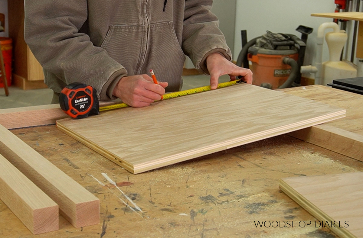 Shara Woodshop Diaries marking pocket hole locations on plywood side panels to build modern nightstand