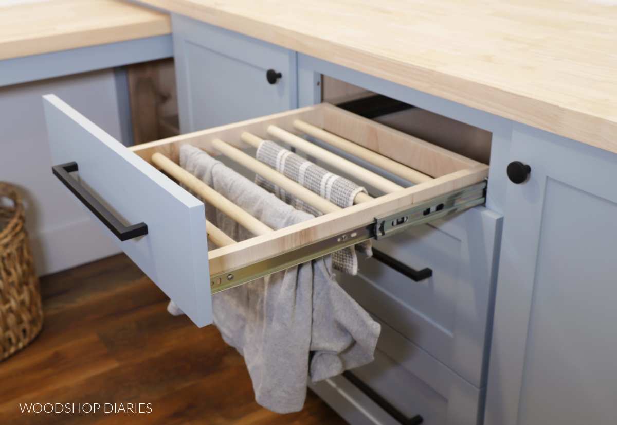 Drying rack installed as a drawer in base cabinet in laundry room