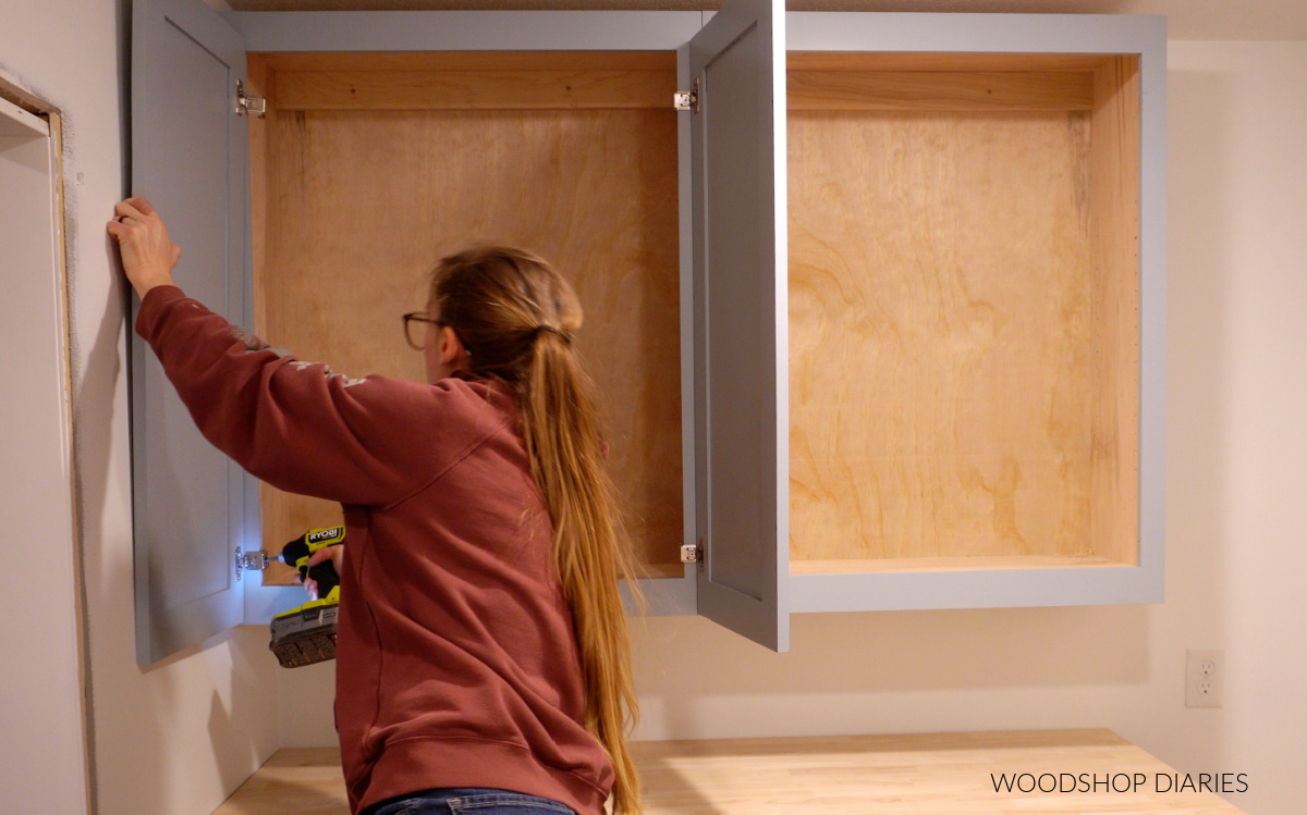 Shara Woodshop Diaries installing cabinet door onto upper cabinets in laundry room