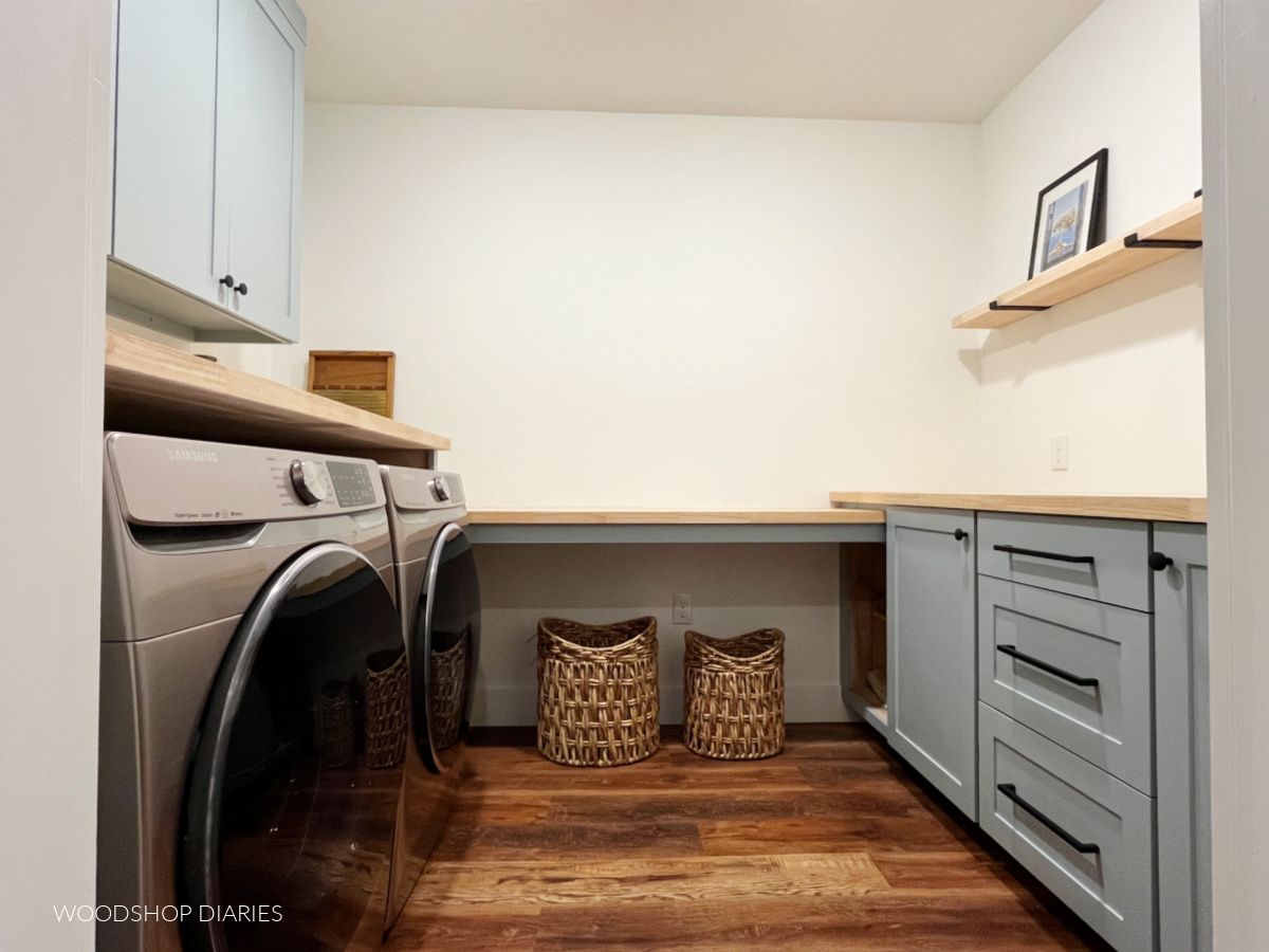 Completed laundry room with built in base cabinets, countertop and wall cabinets painted blue