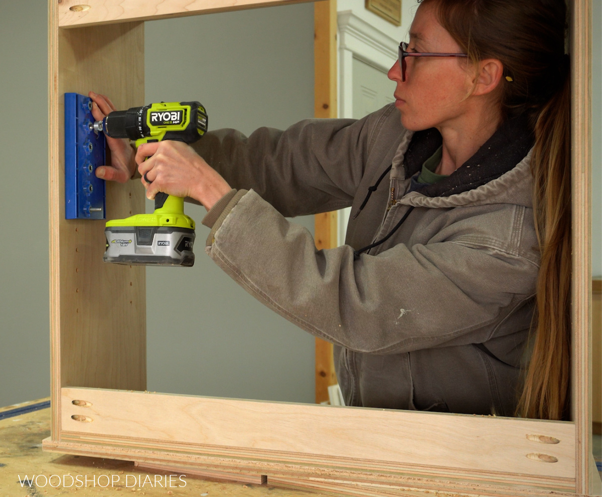 Shara Woodshop Diaries drilling shelf pin holes in cabinet with Kreg Shelf Pin Jig