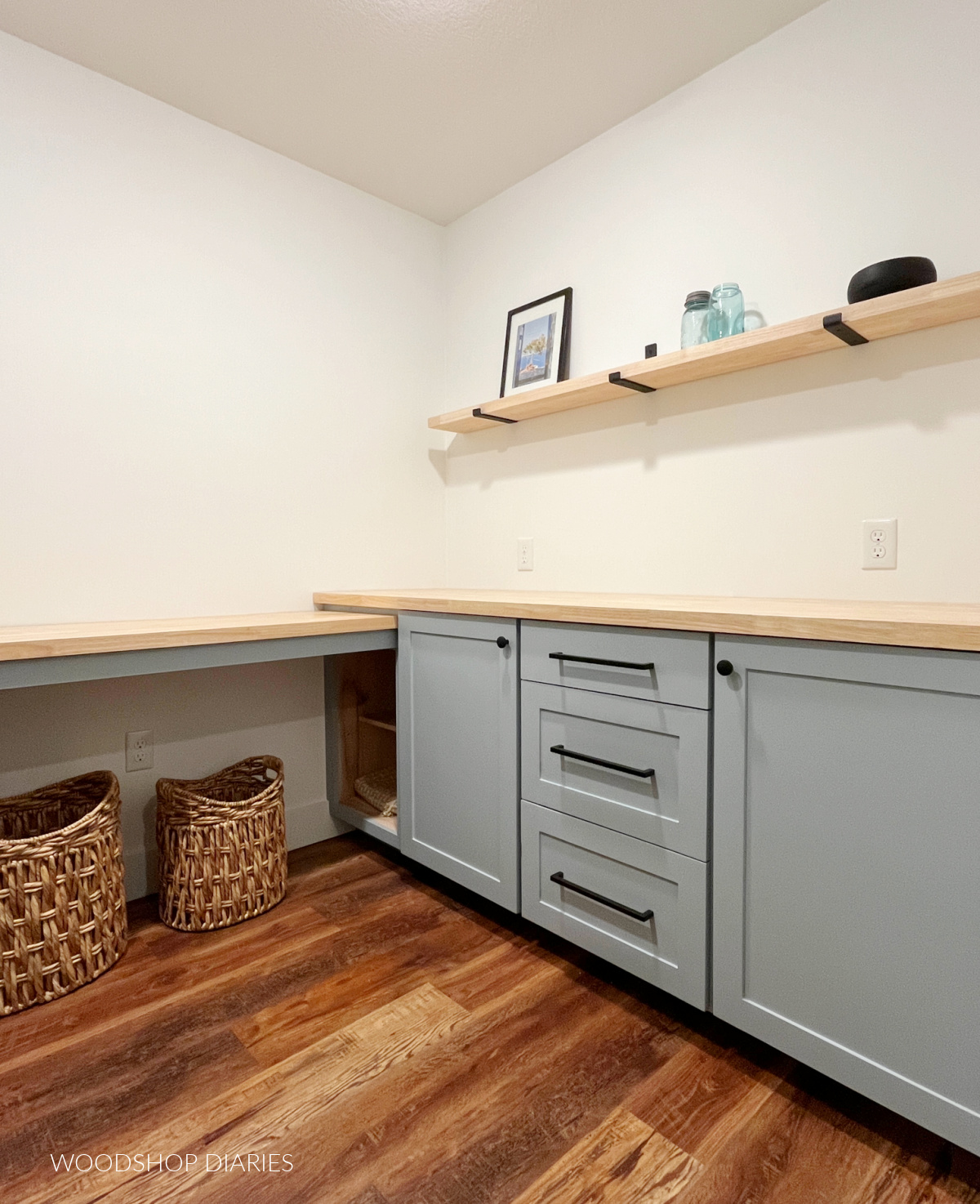 Base cabinets built into laundry room with shelf above