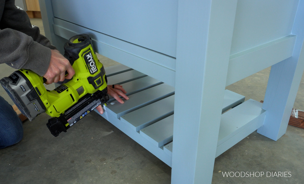 Brad nailing bottom shelf slats in place after painted 